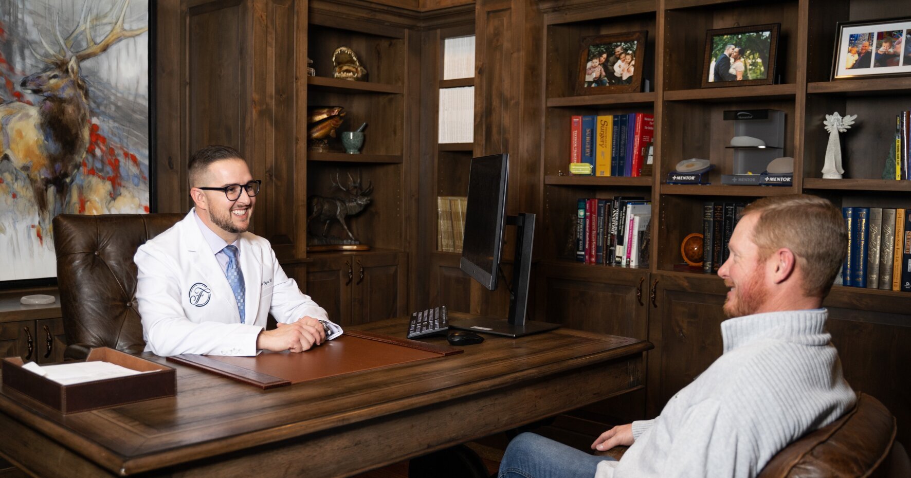 Dr. Matthew Hagan sitting at his desk, talking with a patient
