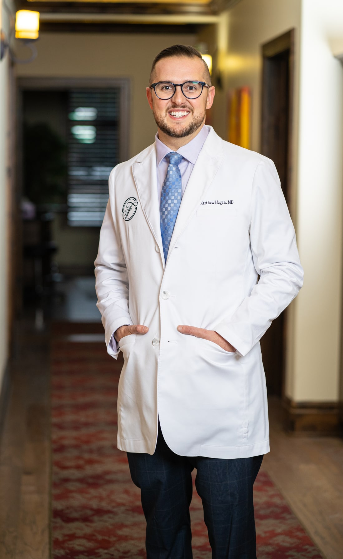 Reading Plastic Surgeon Dr. Matthew Hagan Standing in Hallway